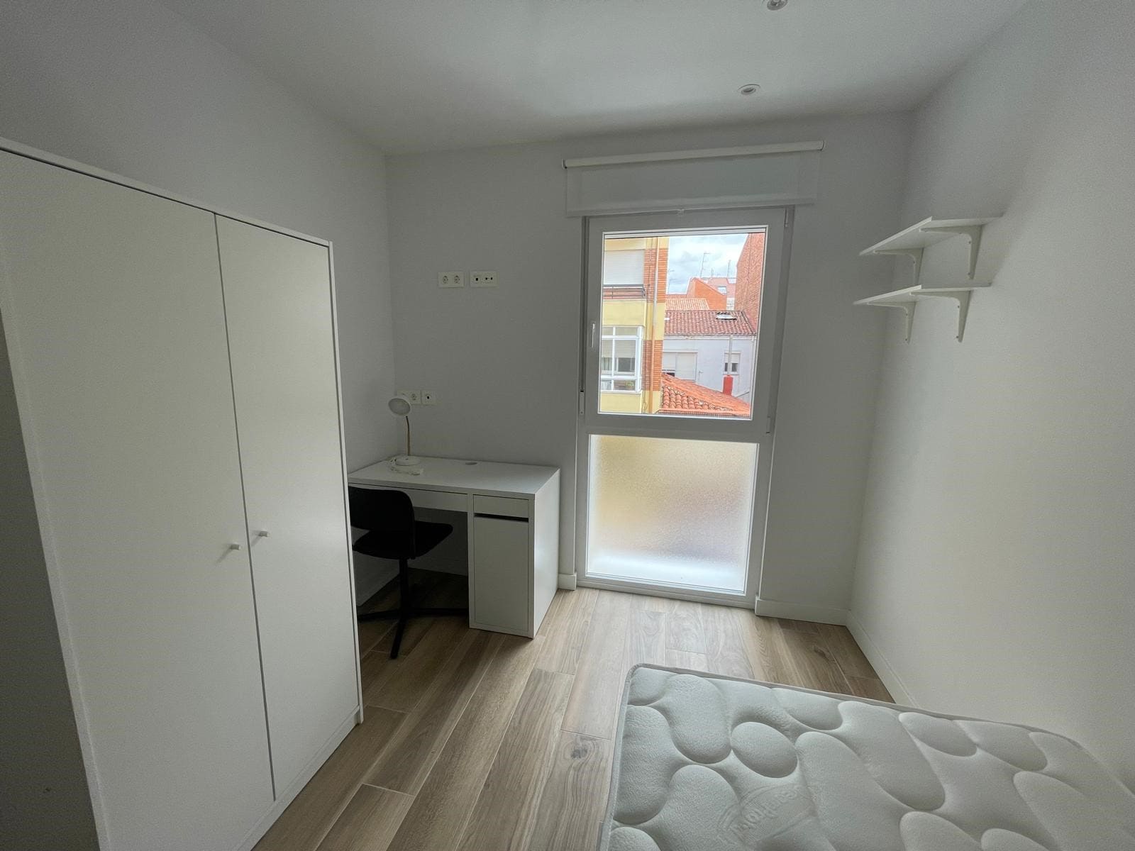 7-min-2 Piso de alquiler en Demetrio de los Ríos en León vista de habitación individual con armario, ventana y buena iluminación